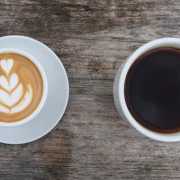 Dos tazas de café sobre una mesa de madera