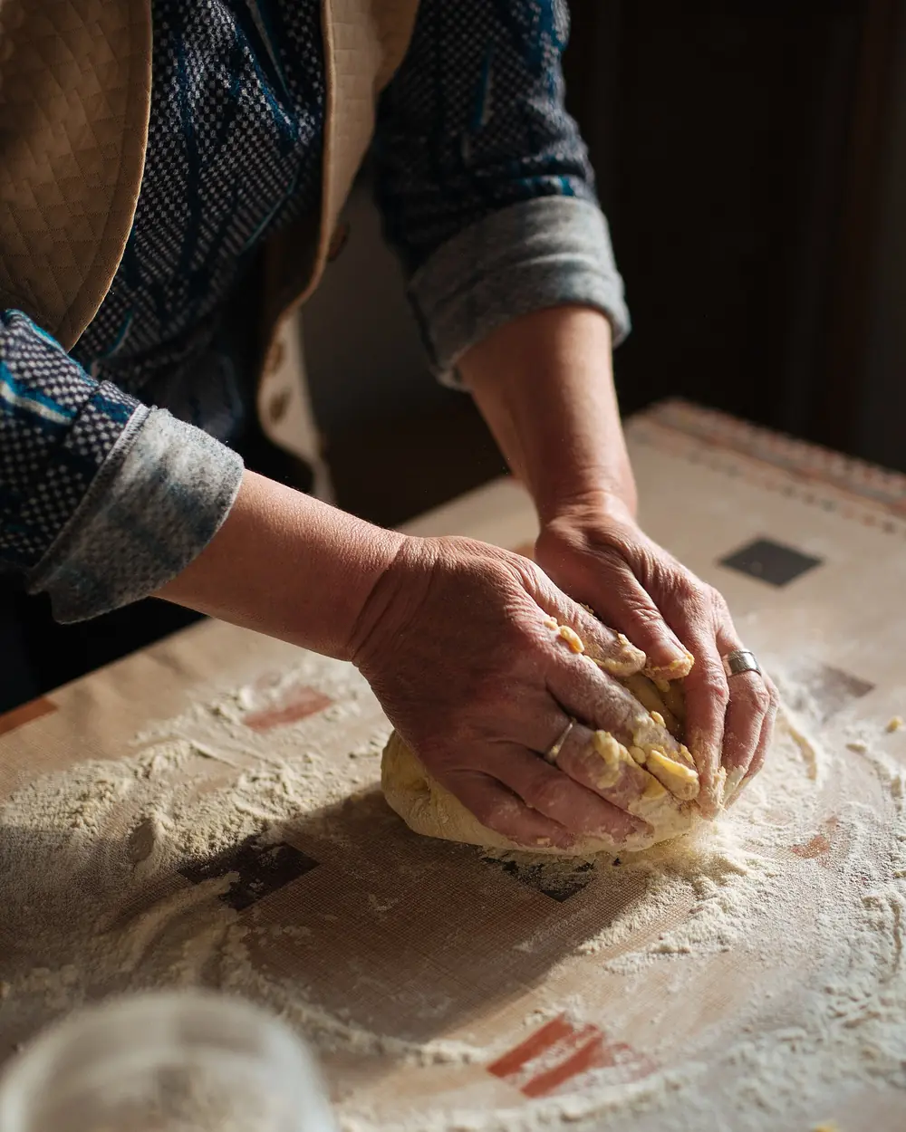 Manos amasando sobre una mesa enharinada